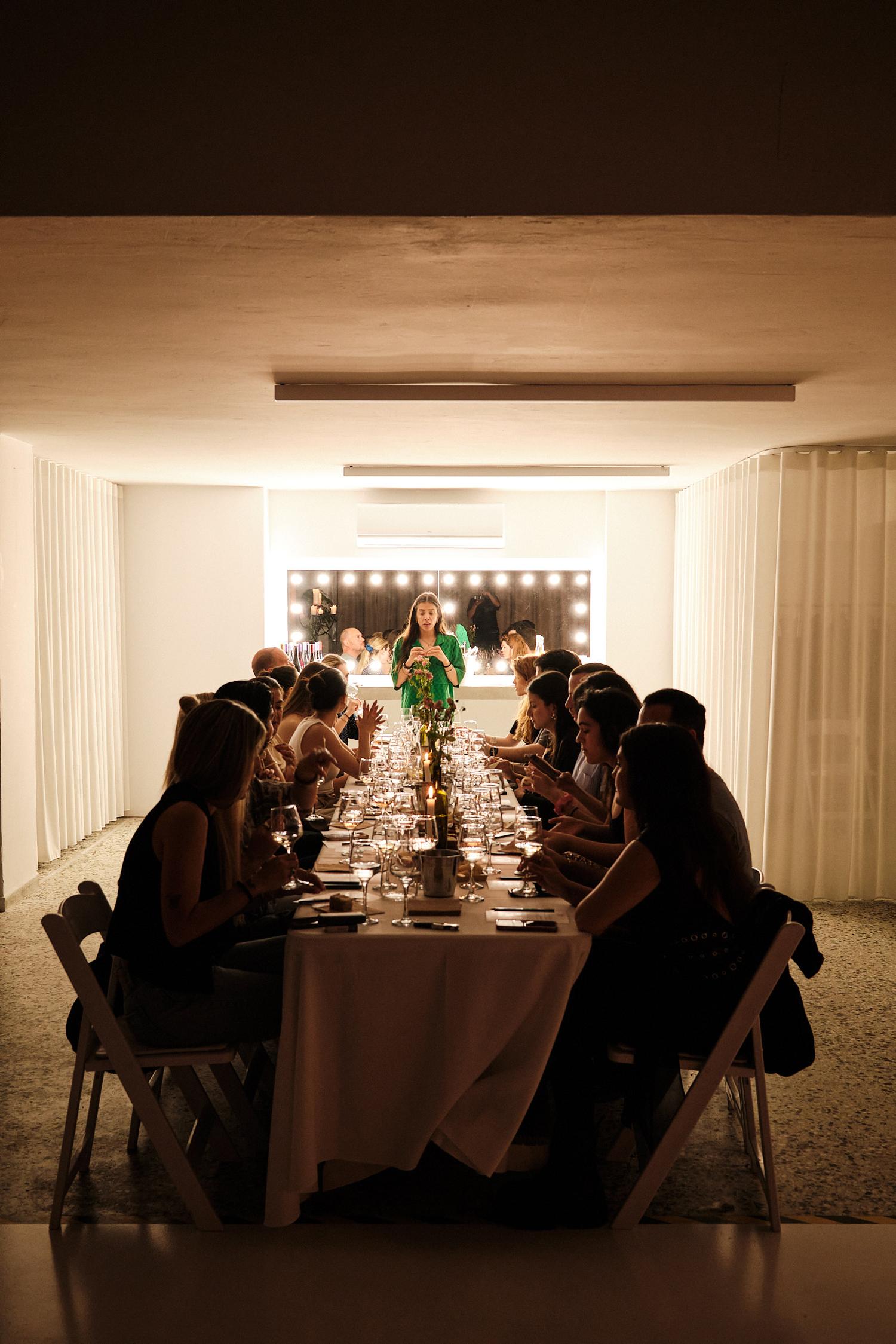 Host addressing guests at wine dinner